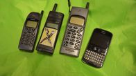 Fyra mobiltelefoner av äldre modell. 