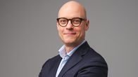 Silmälasipäinen mies harmaassa puvussa. Ylen Media-yksikön uusi johtaja Jyrki Rosenberg.