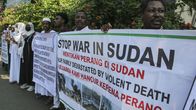 Demonstranter står på rad och håler i plakat. "Stoppa kriget i Sudan".