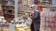 Nainen katselee tuotteita ruokakaupassa.