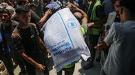 Ihminen kantaa suurta Maailman ruokaohleman WFP:n jauhosäkki väkijoukossa.