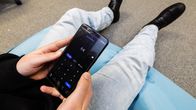 Henkilö käyttää MobilePay-sovellusta älypuhelimella.