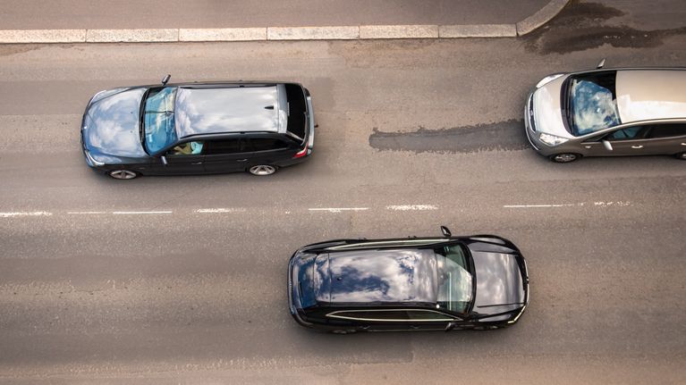Autoja ajamassa tiellä. Kuva on otettu pystysuoraan tien yläpuolelta, niin kutsutusta lintuperspektiivistä.