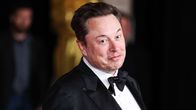 Elon Musk pukeutuneena mustaan pukuun.
