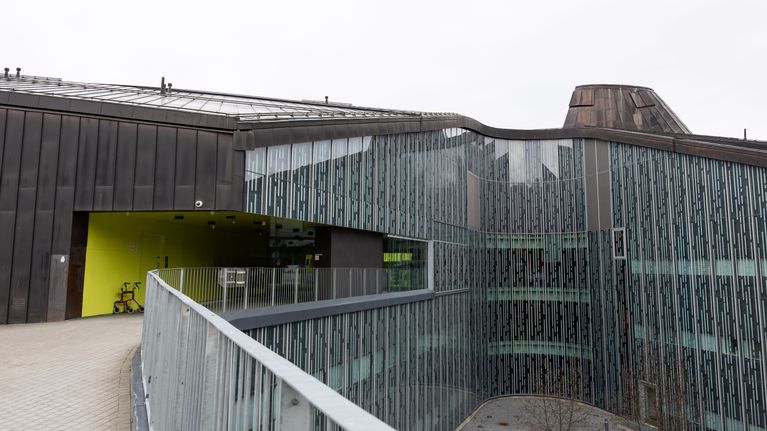 Tipotien sosiaali- ja terveysasema Tampereella. Tummanharmaa rakennus, jonka eteen on pysäköity rollaattori.