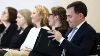 Wille Rydman selaa mustaa kansiota, jonka kannessa lukee Sosiaali- ja terveysministeriö, Ministeri.