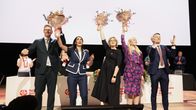 SDP:n vastavalitut puheenjohtat juhlivat lavalla kukkakimput ilmassa. 