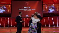 Kaskiksen edustajat halaavat Michelin-tilaisuuden lavalla tähden myöntämisen jälkeen. Heillä on päällään puvut ja naisilla iltapuvut.