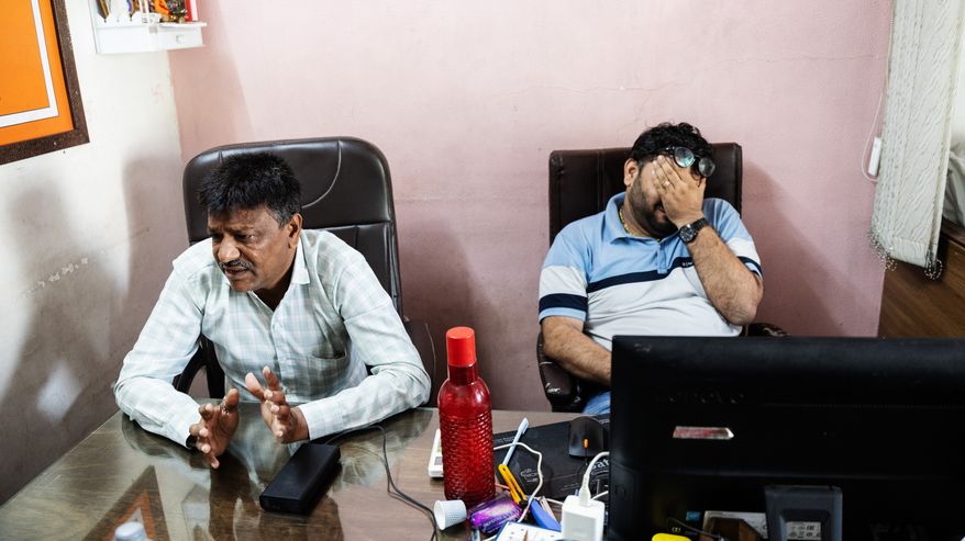 Rameshbhai Devdanbhai Zilariyan ja Konalbhai Kacha istuvat toimistossa.