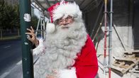 Joulupukki Timo Pakkanen nojaa liikennevaloon Mechelininkadulla.