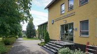 Gul stenbyggnad med texten "Larsmo kommun" på väggen.