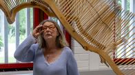 Konneveden Naisten viikon taiteellinen johtaja Kristiina Hurmerinta tarkastelee Mika Heinosen taideteosta Konneveden kirjastossa.