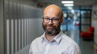 Tony Björk står i en skolkorridor.