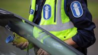 Anonyymi poliisi suorittamassa puhalluskoetta autoilijalle.