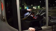 Bussinkuljettaja kuvattuna pleksilasin takaa. Kuvassa näkyvät vain kuljettajan kädet.