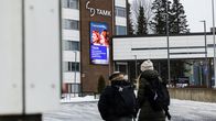 Kaksi henkilöä kävelee talvisäässä kohti Tampereen ammattikorkeakoulun tiilirakennusta.