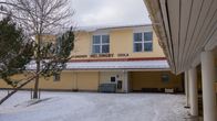 Helsingby skola är en ljusgul skolbyggnad här fotograferats under vintertid för det finns snö på marken. Det är ett grått, molnigt väder.
