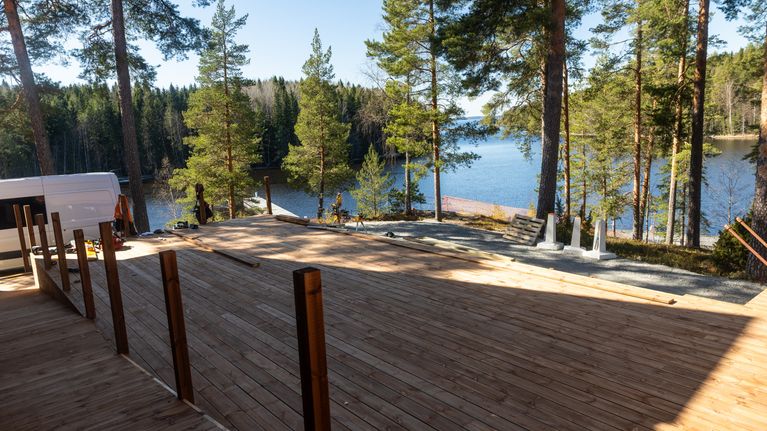 Suuri terassi, jonka rakentaminen on kesken. Taustalla keväinen järvinäkymä.