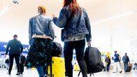 Matkustajat liikkuvat matkatavaroiden kanssa lentokentän terminaalissa.