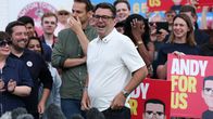 Andy Burnham ihmisjoukon keskellä. Yleisö pitää käsissään punaisia vaalikylttejä.
