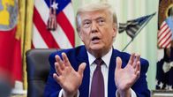 Donald Trump kohottaa käsiään ja katsoo yläviistoon suu auki.