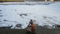 Henkilö peseytyy Intiassa saastuneen joen vedellä.
