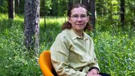 Metsänomistaja Riitta Torikka istuu oranssilla tuolilla.