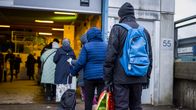 Photo shows people queueing for free food aid in Helsinki.