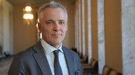 Opetusministeri Anders Adlercreutz seisoo Eduskunnan valtiosalissa kameraan katsoen.