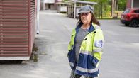 Nainen seisoo kerrostaloalueen pihalla.