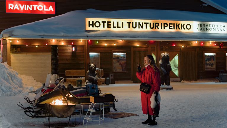 Ohjus-elokuvan päähenkilö Niina seisoo Hotelli Tunturipeikon edessa tupakka kädessään.