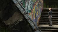 Nainen seisoo portaikossa jossa on paljon graffiteja.