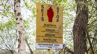 Kuvassa on rajavyöhykkeen kieltoalueesta kertova varoituskyltti, jossa lukee "SEIS" ja "STOP". 