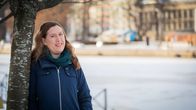 En kvinna (Yasmin Nyqvist) lutar sig mot ett träd.