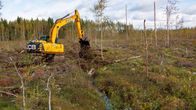 Kaivinkone ennallistamassa suoaluetta. Se peittää kaivettuja metsäojia umpeen.