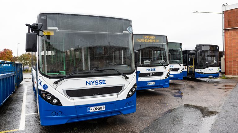 Busseja parkissa varikolla sateisena päivänä.
