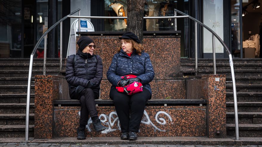 Riitta Laine ja Paula Koivisto istuskelevat Jyväskylän keskustassa.