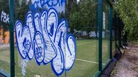 Graffiteja maalattuna padel-kentän plekseihin.