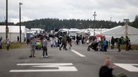 Ihmisiä asfalttikentällä. Taustalla näkyy valkoisia telttarakennuksia.