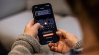 Henkilön kädessä olevassa puhelimessa OP:n mobiilisovellus.
