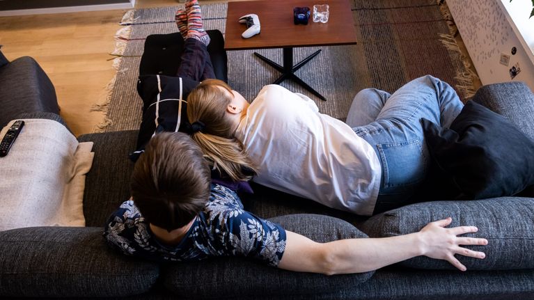 Pariskunta sohvalla katselee televisiota.