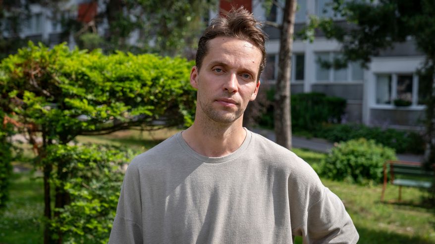 Tutkija Antti Tarvainen poseeraa kerrostalon piha-alueella.