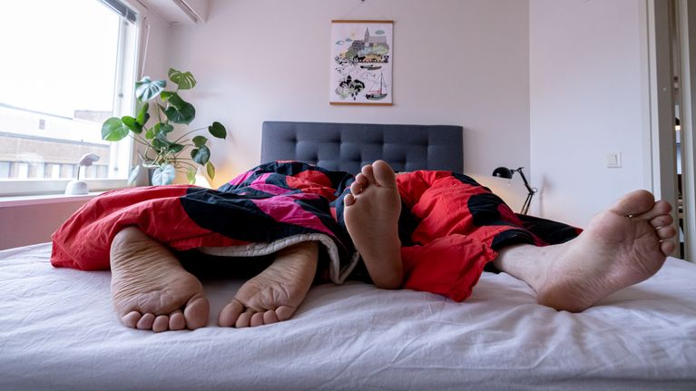 Pariskunta nukkuu parivuoteessa.