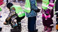 Lapset odottavat jonossa leikkipuiston portilla.