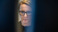 Nainen istuu tietokoneella ja katsoo näyttöjä.