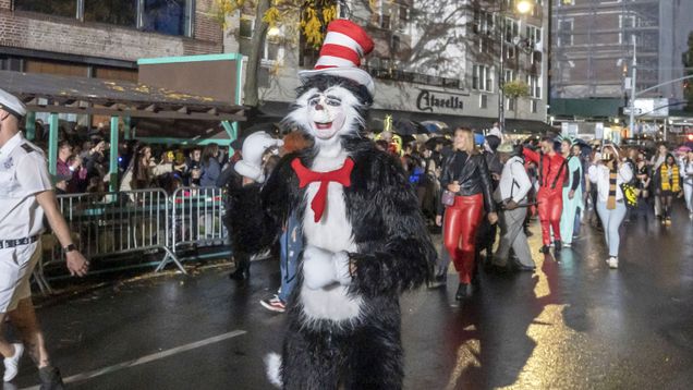 A person dressed up as the Cat in the Hat walks in a street parade.