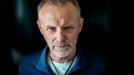Kirjailija Jo Nesbø katsoo suoraan kameraan lähikuvassa tummaa taustaa vasten.