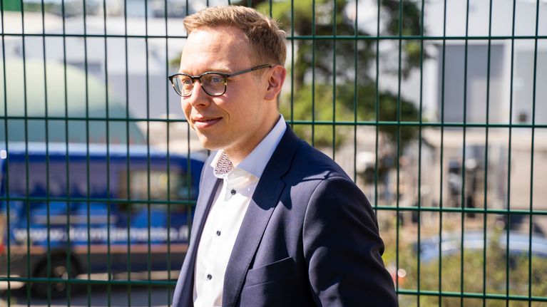 Työministeri Matias Marttinen seisoo ulkona aurinkoisena päivänä.