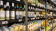 Wine lined up on grocery store shelves. 