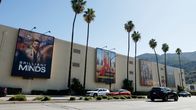Warner Bros -studioiden rakennus, isoja julisteita seinillä ja palmuja etualalla. 